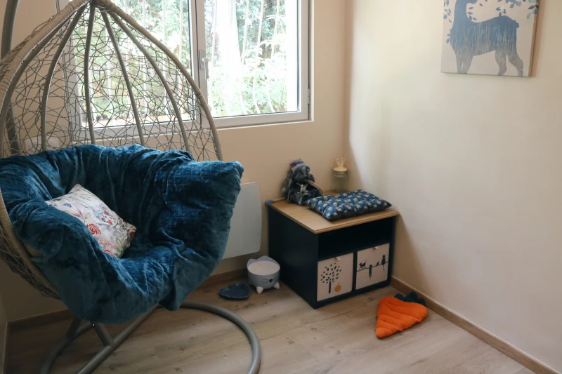 Chambre Calidà : chaise suspendue côté fenêtre et fontaine à eau — pension chat et lapin à Nîmes